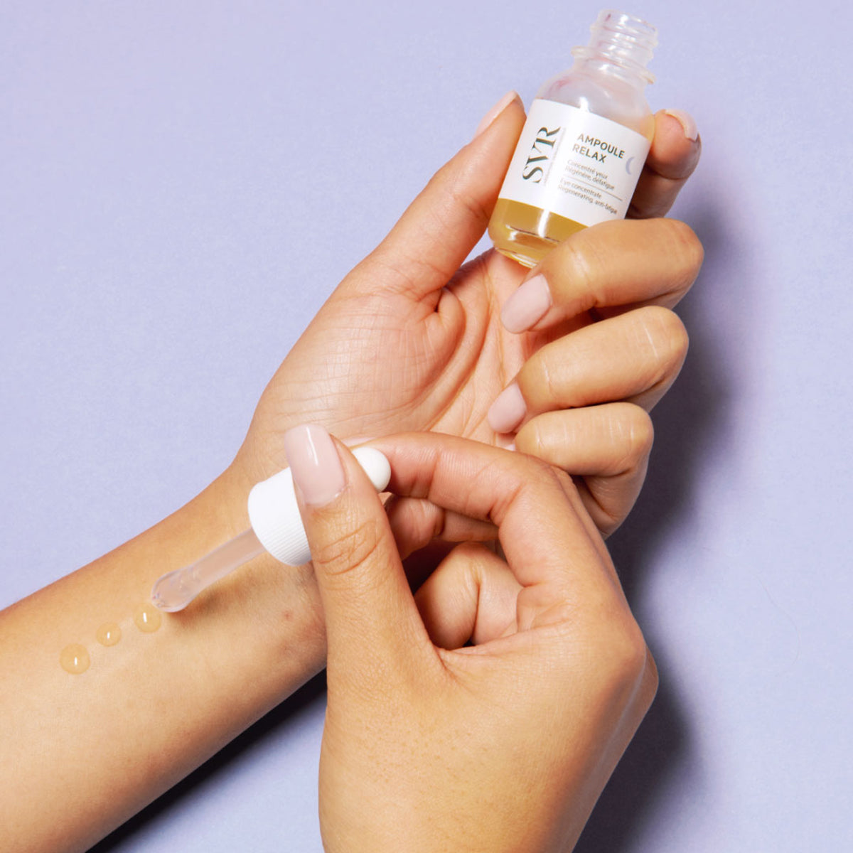 SVR Ampoule Relax Augenkonzentrat mit Pipette, das ein goldenes Oleogel auf den Unterarm aufträgt.