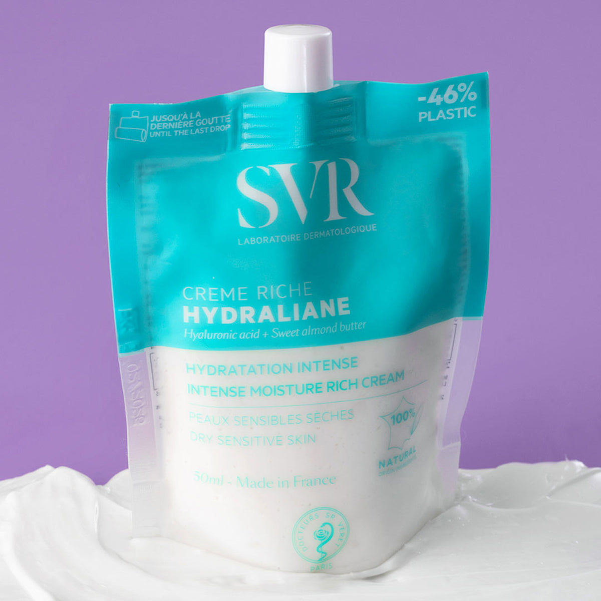 SVR Hydraliane Crème Riche in einer türkisen 50ml-Nachfüllverpackung auf weißer Creme vor lila Hintergrund.