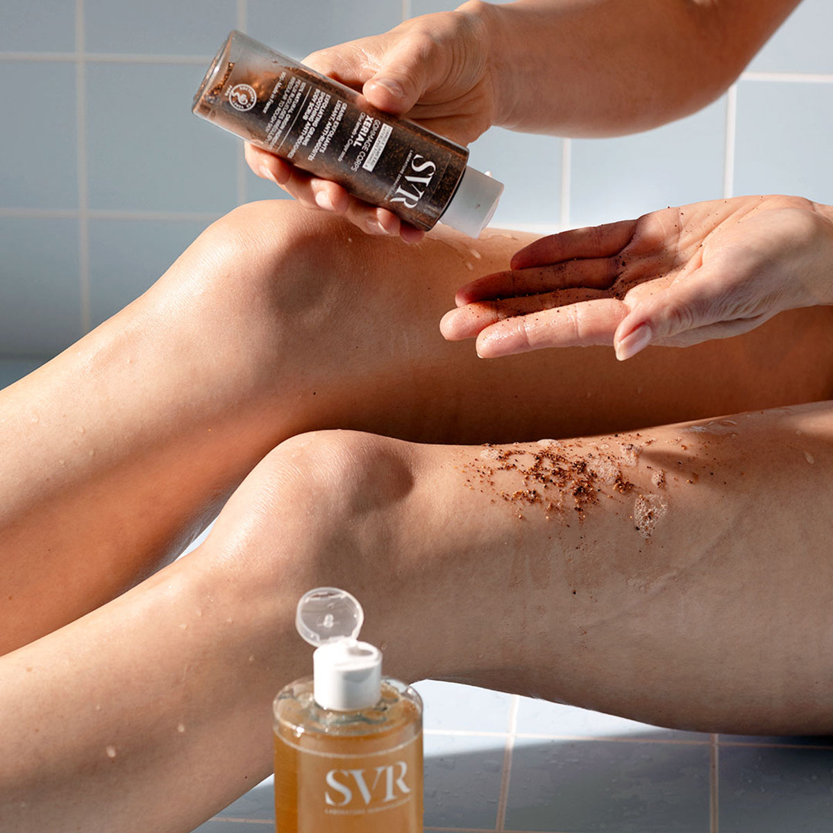 SVR Xerial Gommage Peeling mit braunen Oliven- und Traubenkernen wird auf das Knie aufgetragen für glatte, weiche Haut.