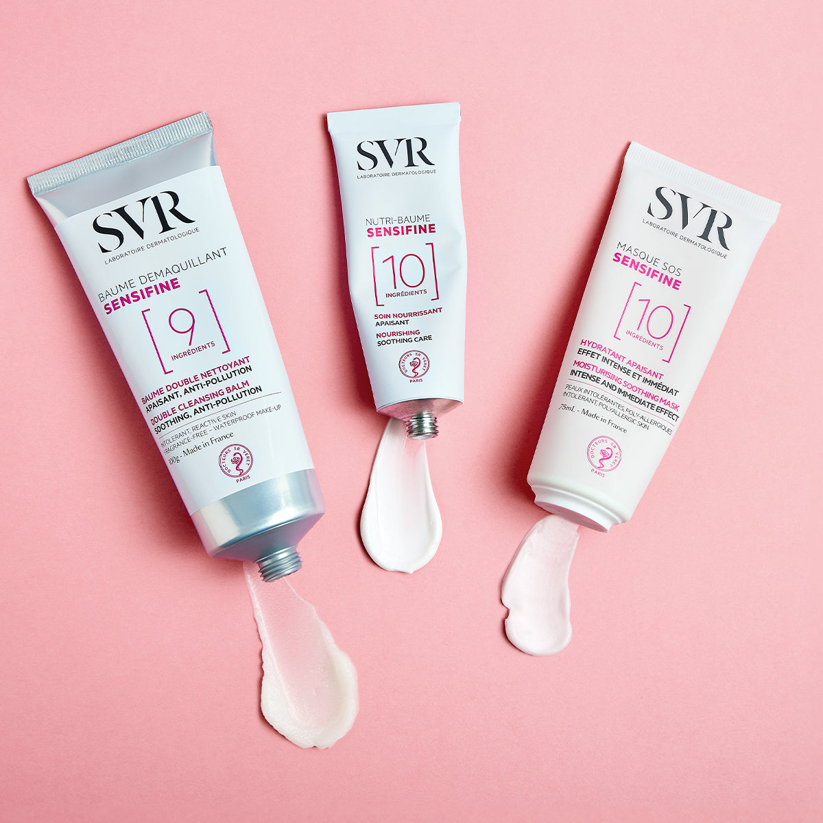 Three SVR SENSIFINE skincare tubes on a pink background with white cream swatches squeezed from each.