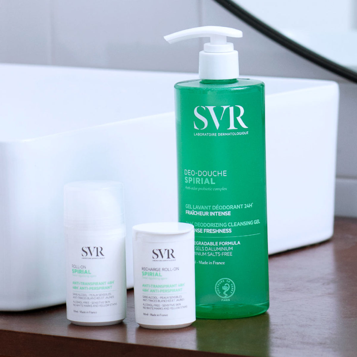 SVR Spirial Déo-Douche Duschgel in grüner Pumpflasche neben zwei weißen SVR Spirial Anti-Transpirant Roll-on Produkten.