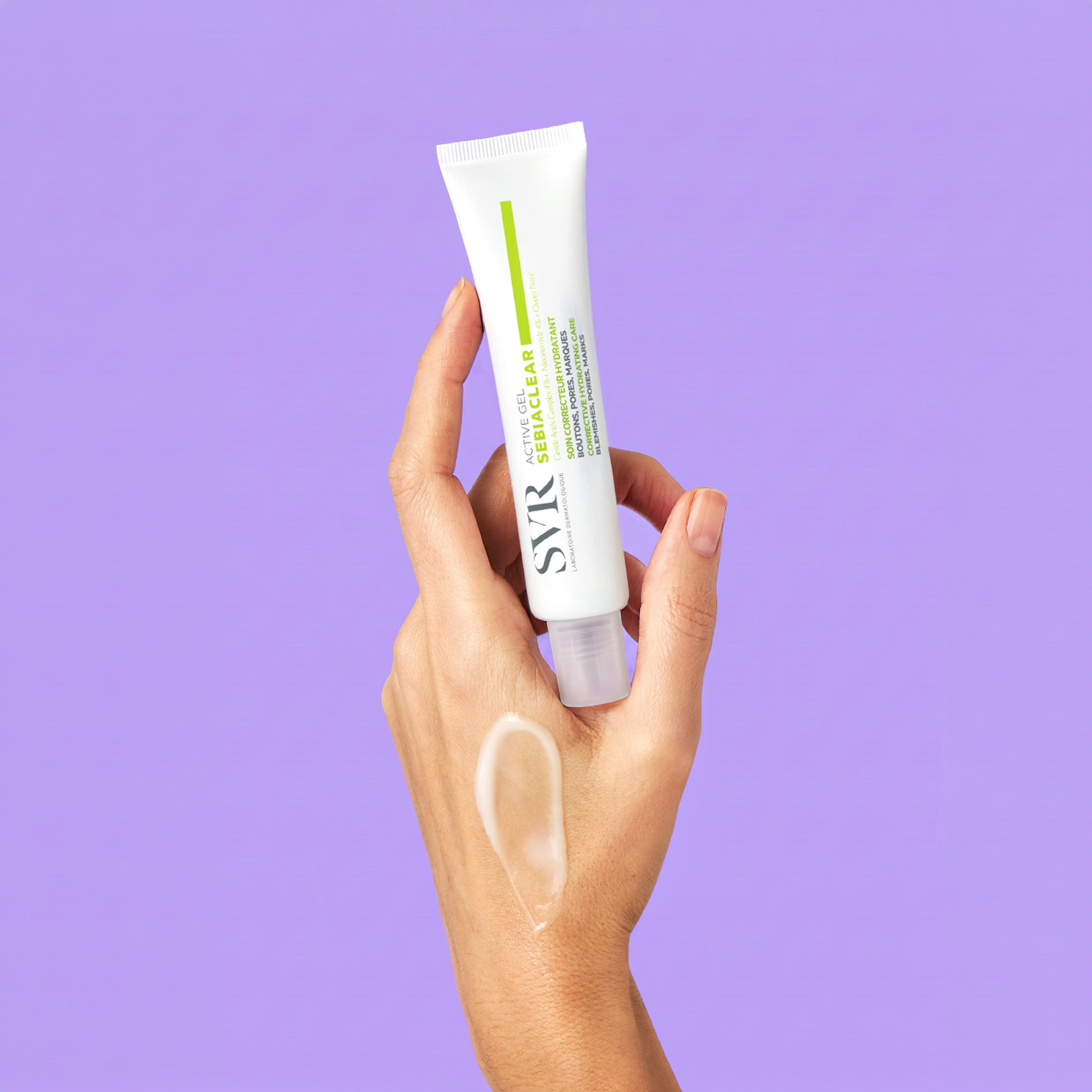 Hand holding a white SVR Sebiaclear Active Gel tube with a clear gel swatch on skin against a purple background.