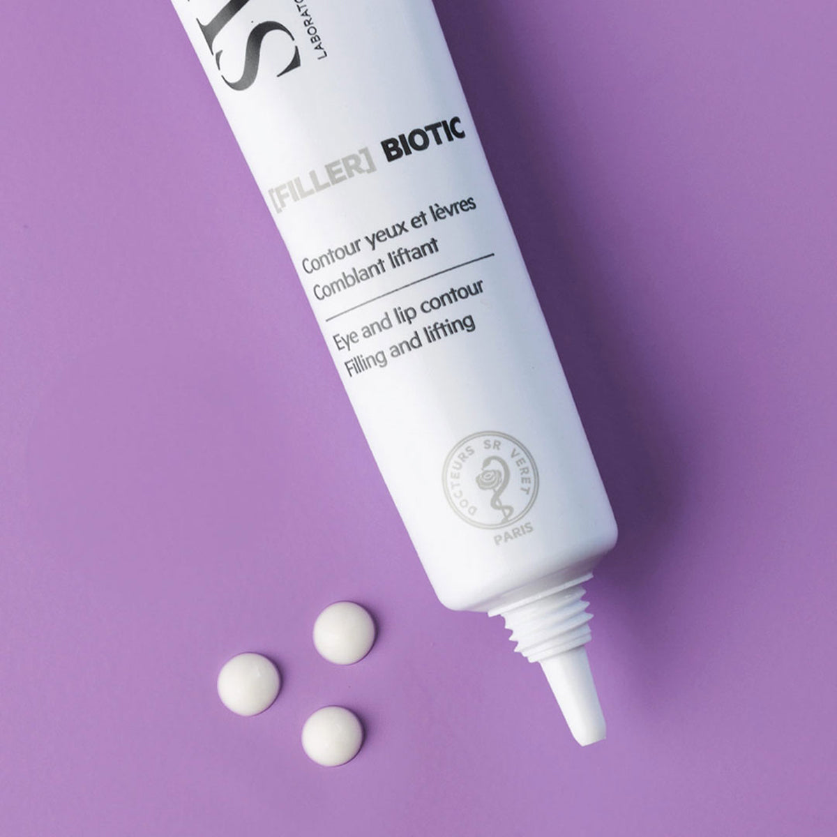 Weiße SVR Biotic Filler Tube für Augen- und Lippenkonturen mit drei Creme-Punkten auf lila Hintergrund.