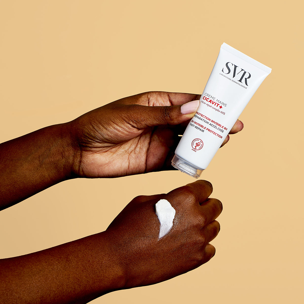 Weiße SVR CICAVIT+ Handcreme-Tube, aus der eine kleine Menge weißer Creme auf den Handrücken aufgetragen wird.