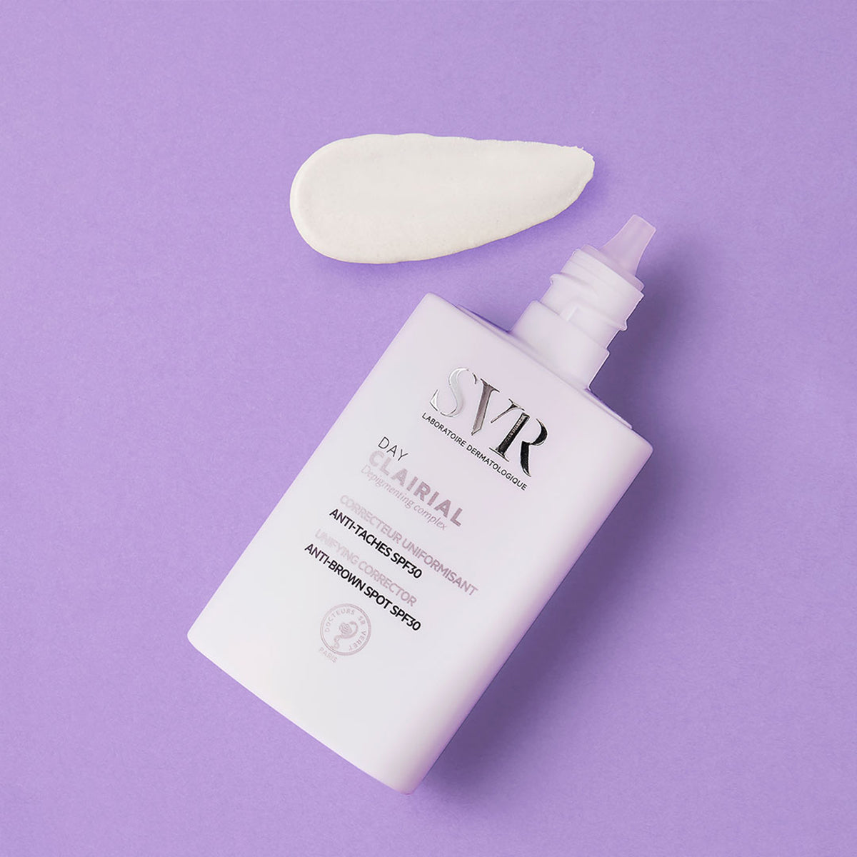 SVR Clairial Day Anti-Pigmentflecken-Creme in weißer Flasche mit Cremeklecks auf lila Hintergrund.