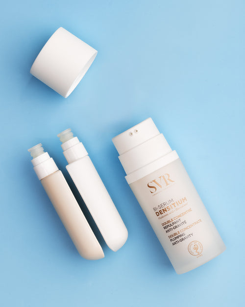 SVR Densitium Bi-Sérum dual-chamber pump bottle with white cap and two separate serum refills on a blue background.