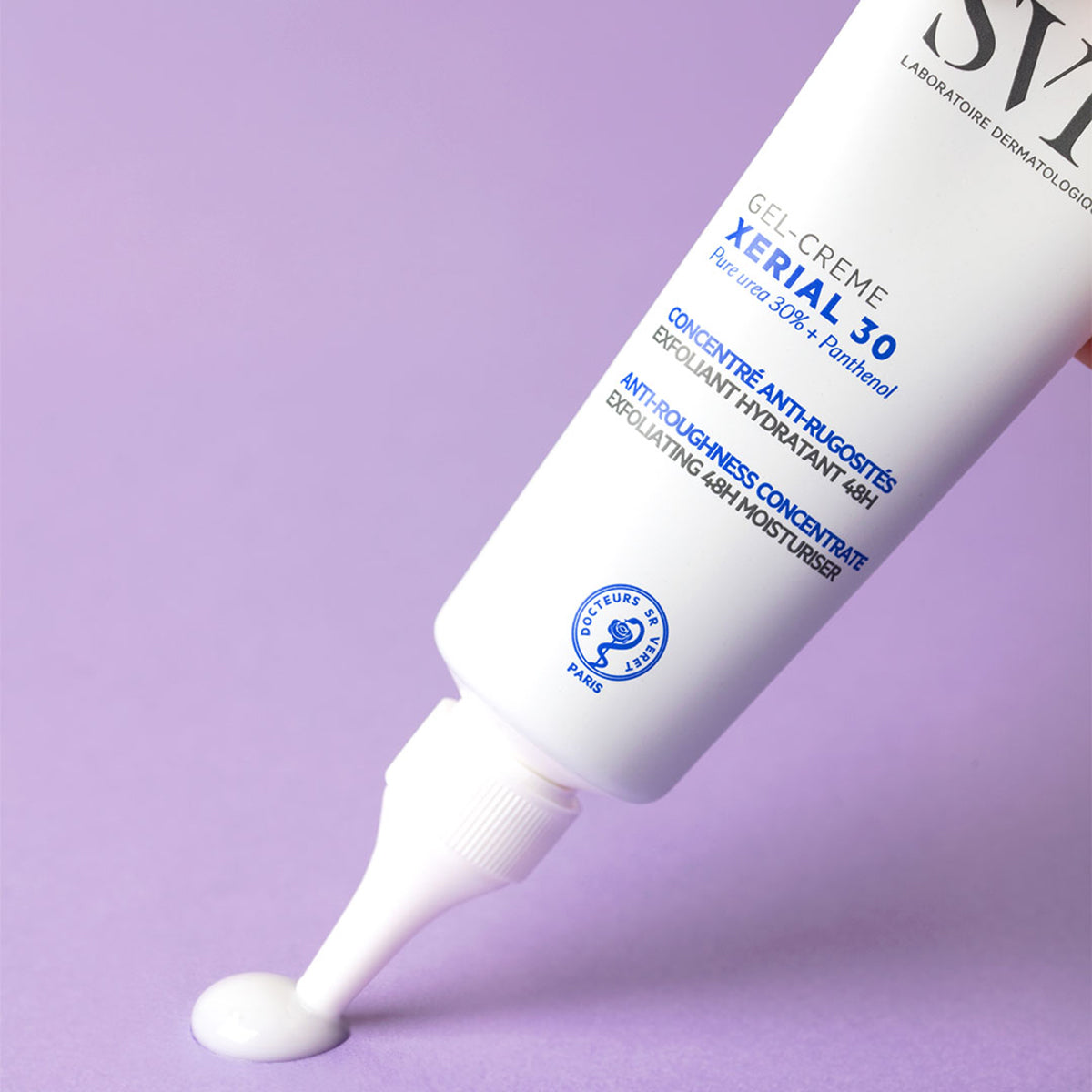 Weiße SVR XERIAL 30 Gel-Crème Tube mit Präzisionsspitze, die weiße Creme auf einen hellvioletten Hintergrund abgibt.