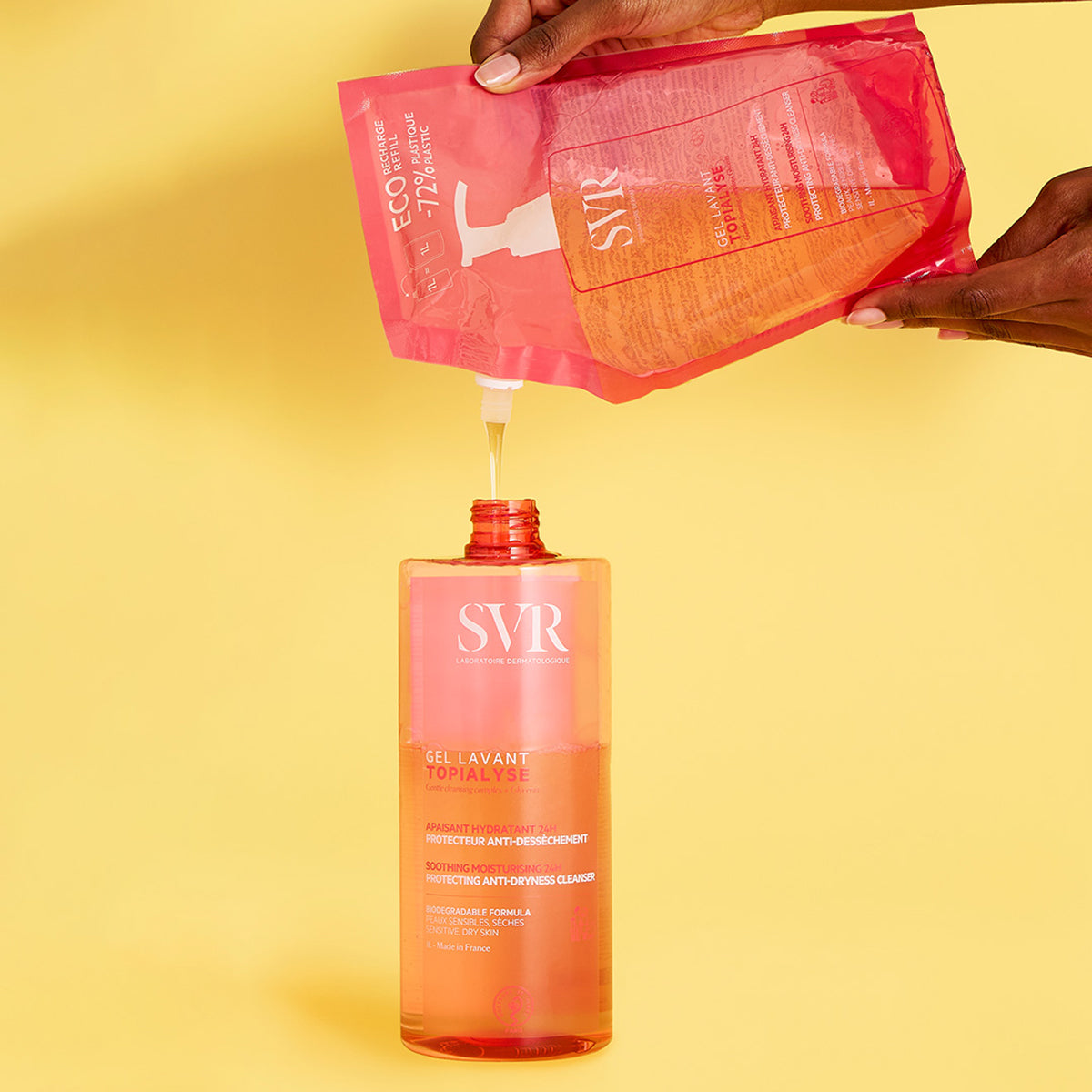 SVR TOPIALYSE Gel Lavant wird aus einem rosa Öko-Nachfüllbeutel in eine transparente 1-Liter-Flasche auf gelbem Hintergrund gefüllt.