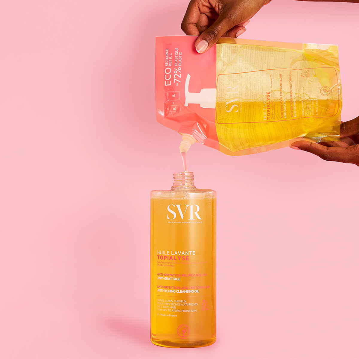 SVR TOPIALYSE Huile Lavante Reinigungsöl wird aus einem rosa-gelben Nachfüllbeutel in eine transparente Flasche gefüllt.