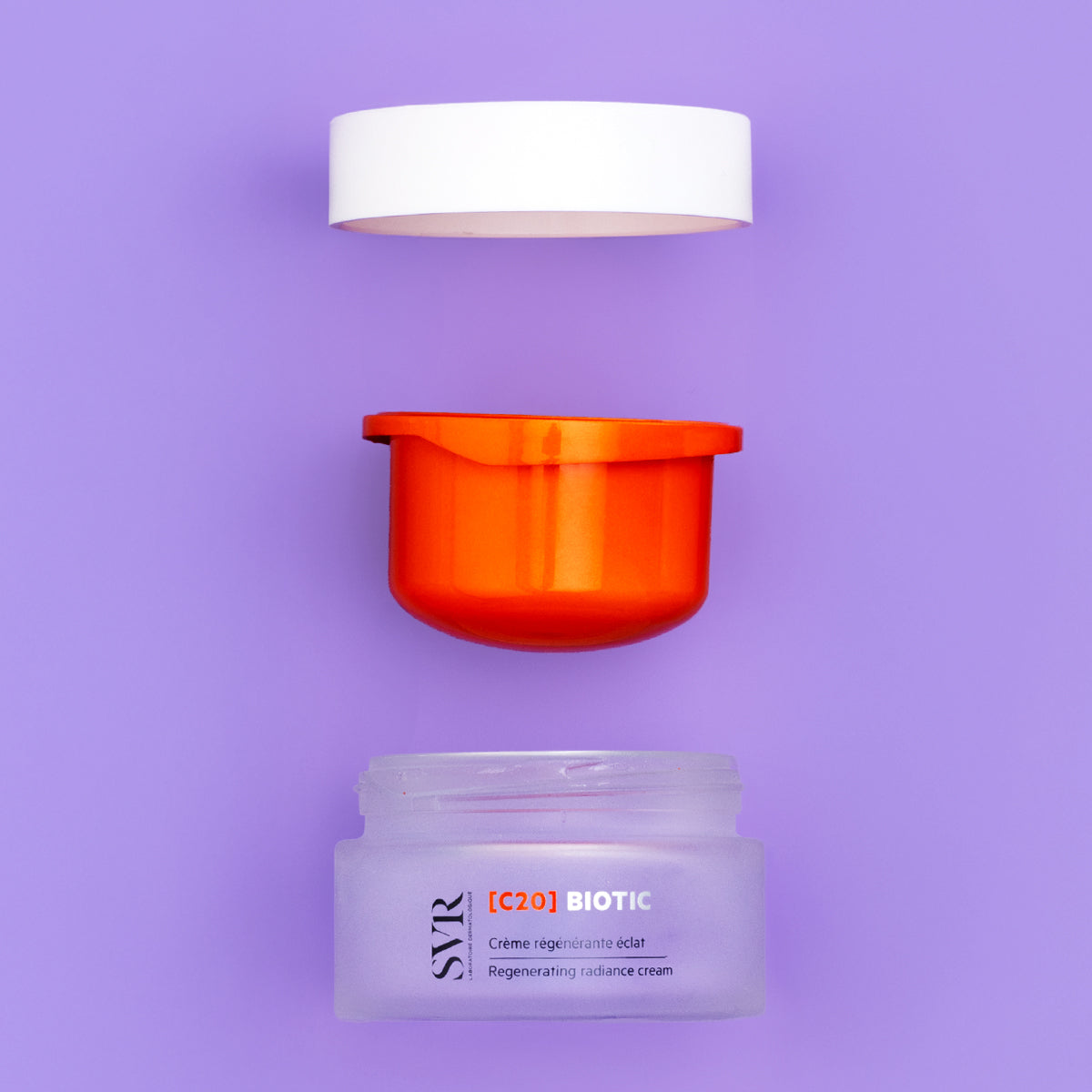 SVR [C20] Biotic regenerating radiance cream in a frosted glass jar with an orange inner container and white lid.